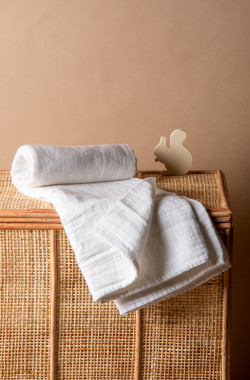 White swaddle blanket on a wicker box