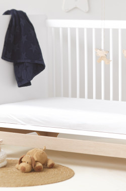 Protège-matelas imperméable bébé en situation dans un univers de chambre de bébé